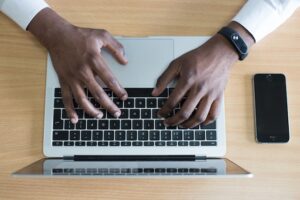 Hands typing on a laptop's keyboard.